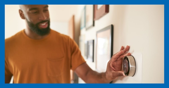 man adjusting thermostat
